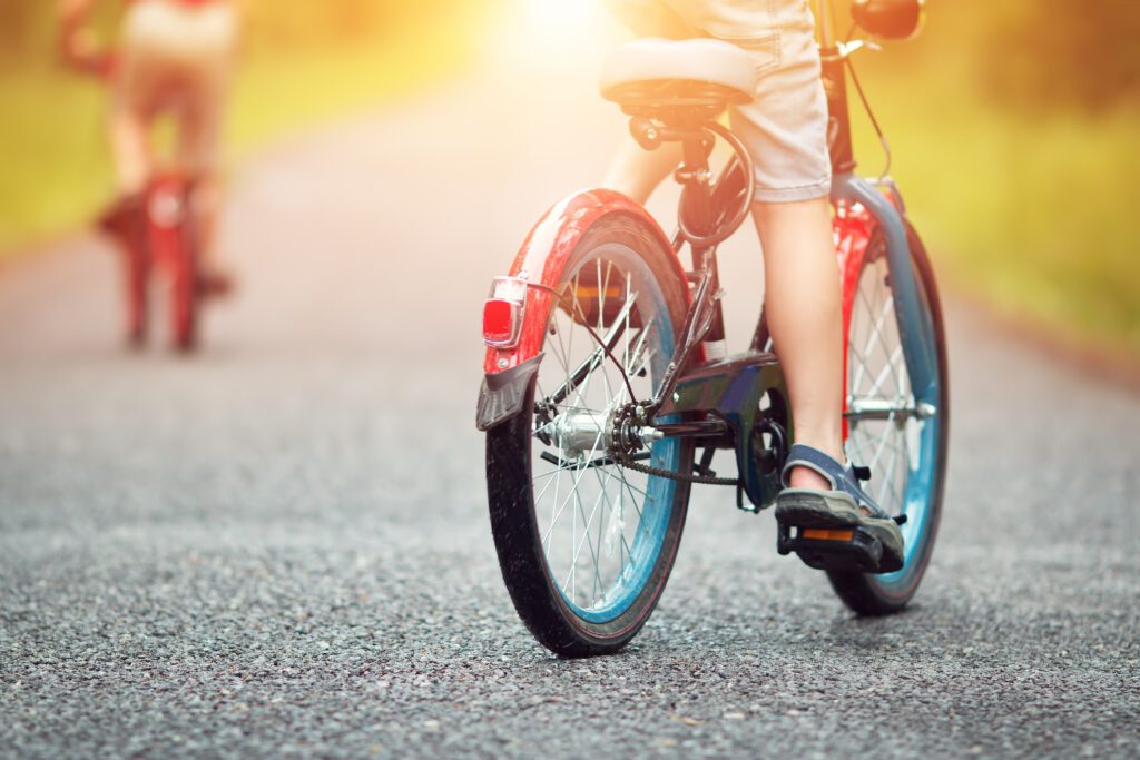 children on a bicycle at asphalt road in early morning