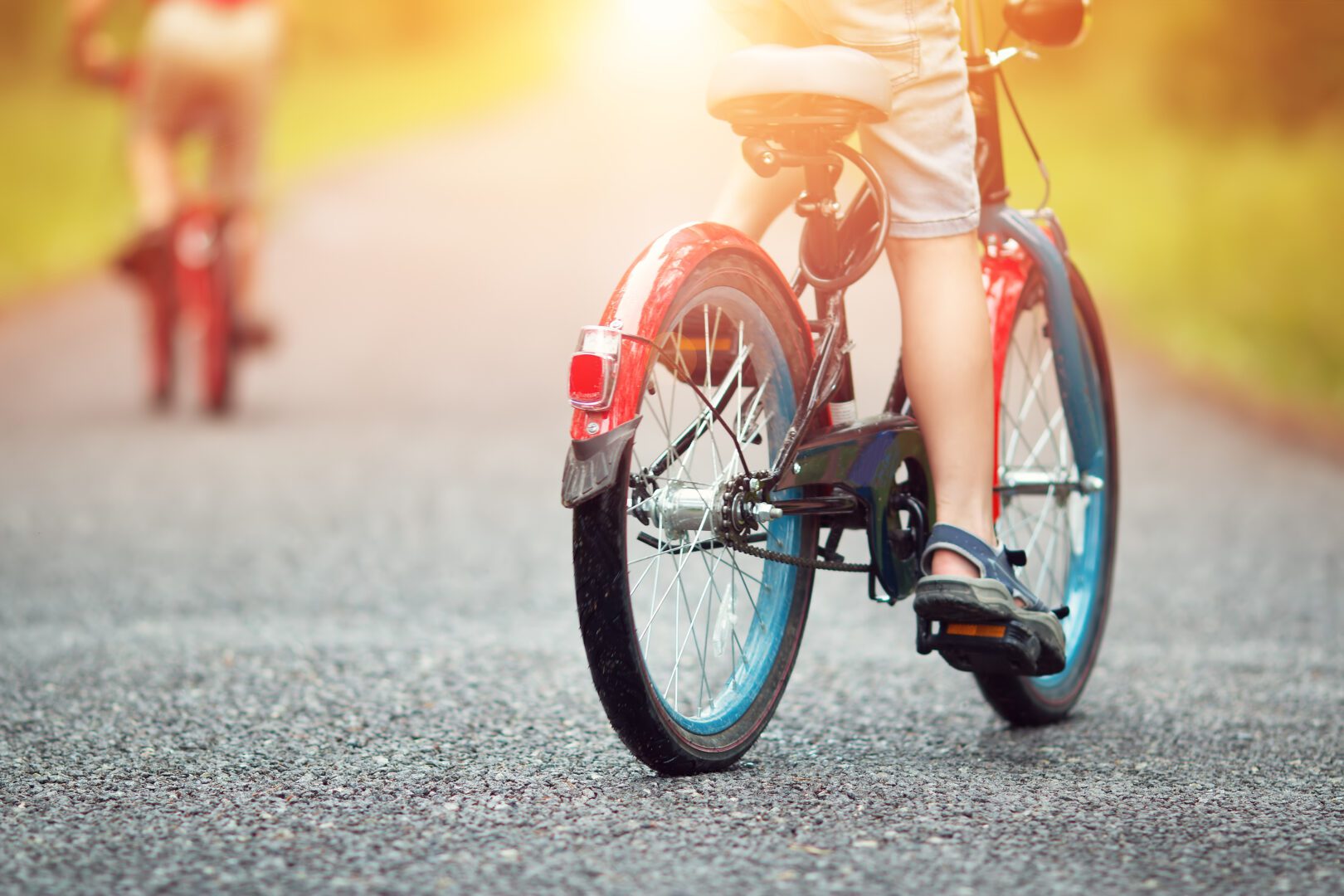 children on a bicycle at asphalt road in early morning