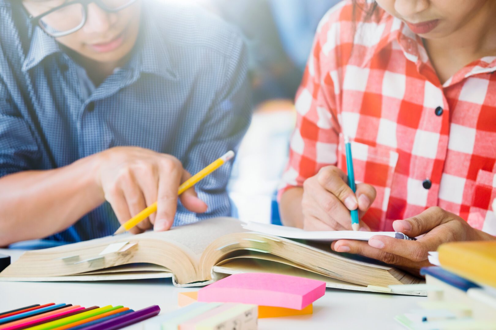Parent helping student with homework surrounded with school supplies