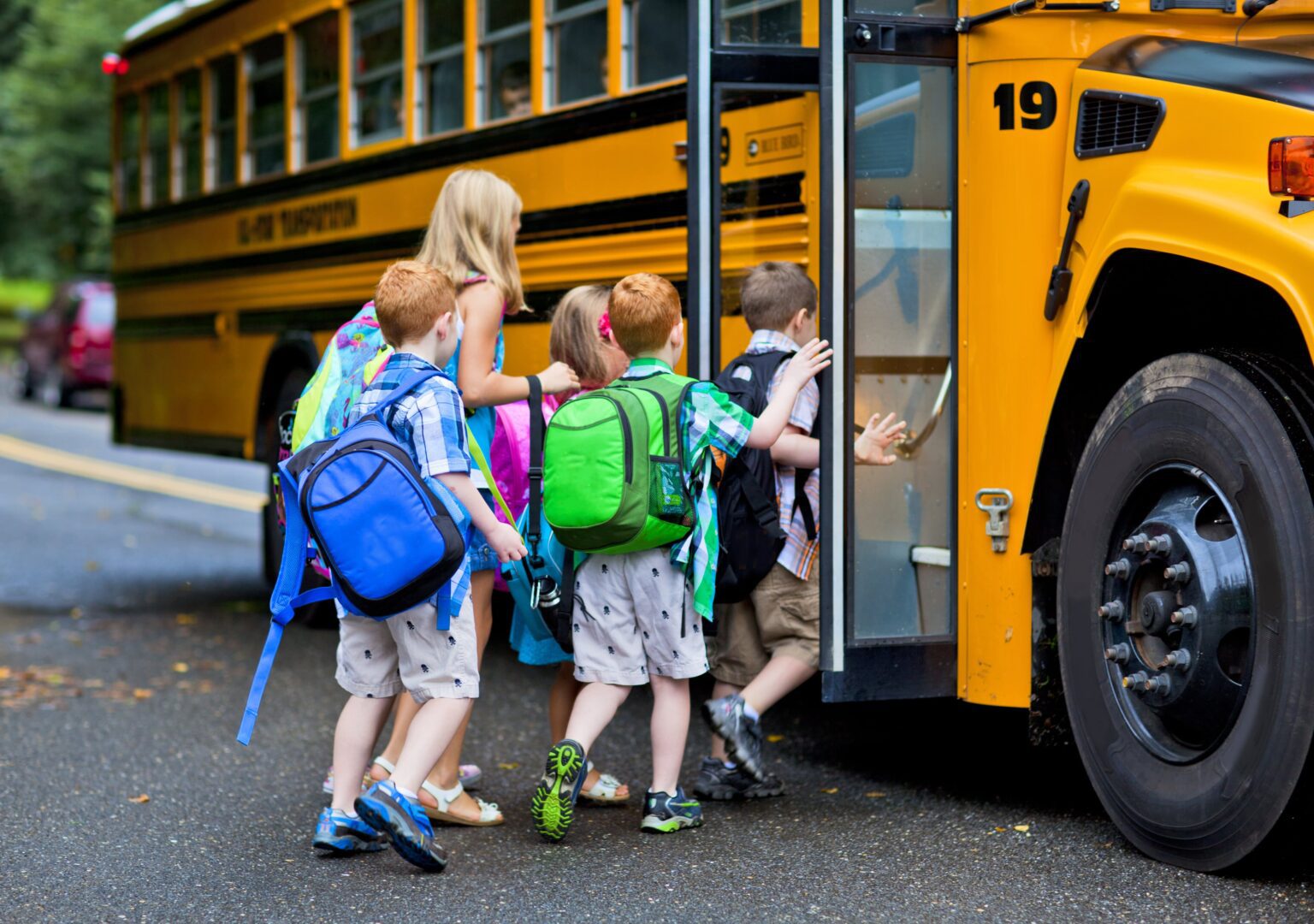 children getting on a school bus